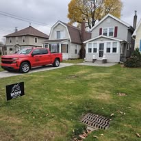 Rockstar Roofing branded truck and yard sign at a completed job site