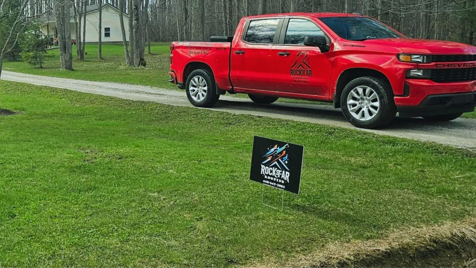 Rockstar Roofing branded Chevy Silverado truck and yard sign at a completed Northeast Ohio roof replacement job site